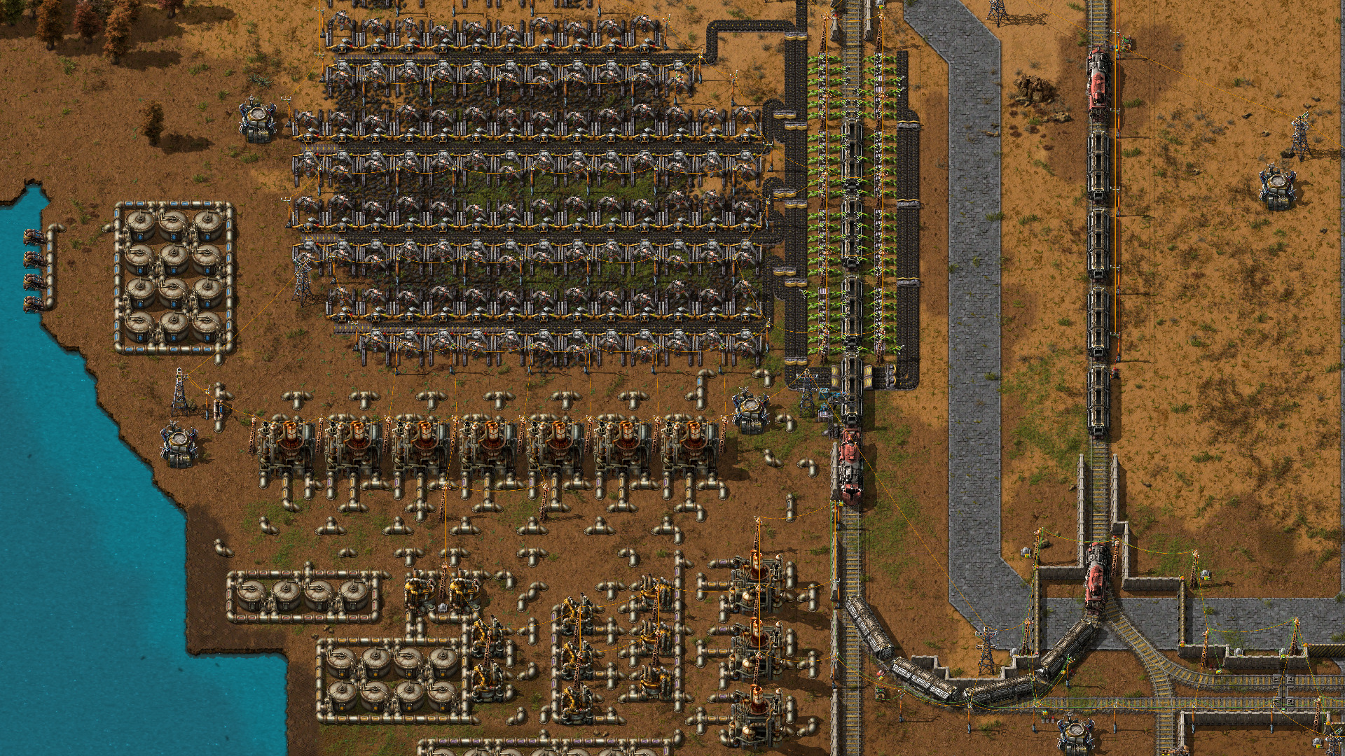 水辺に発電設備と生産ラインが並ぶFactorioの工場