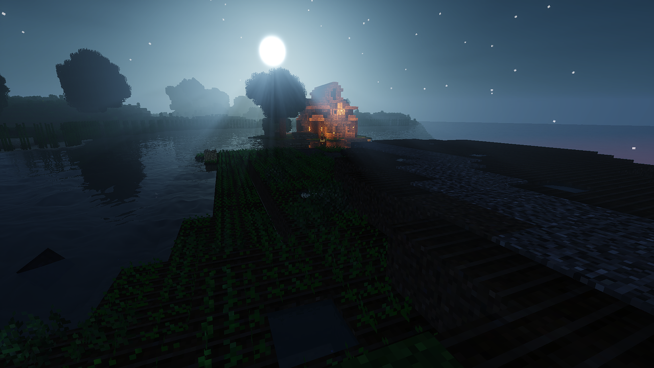 Minecraftの水辺で、月明かりの下に家の明かりがともる夜の風景