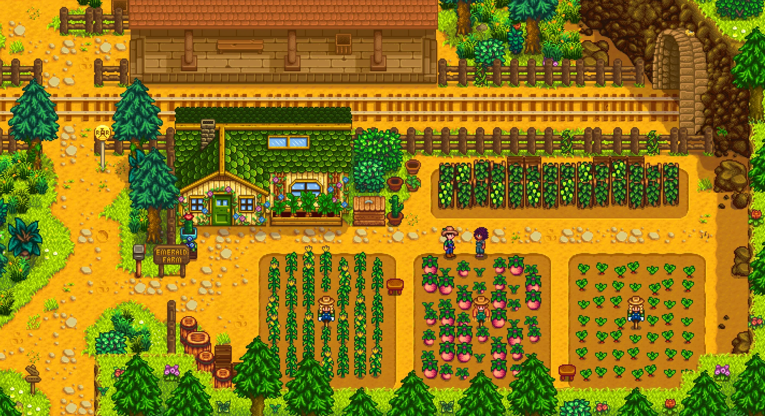 線路のそばに緑の屋根の家と畑があるSVEのEmerald Farm