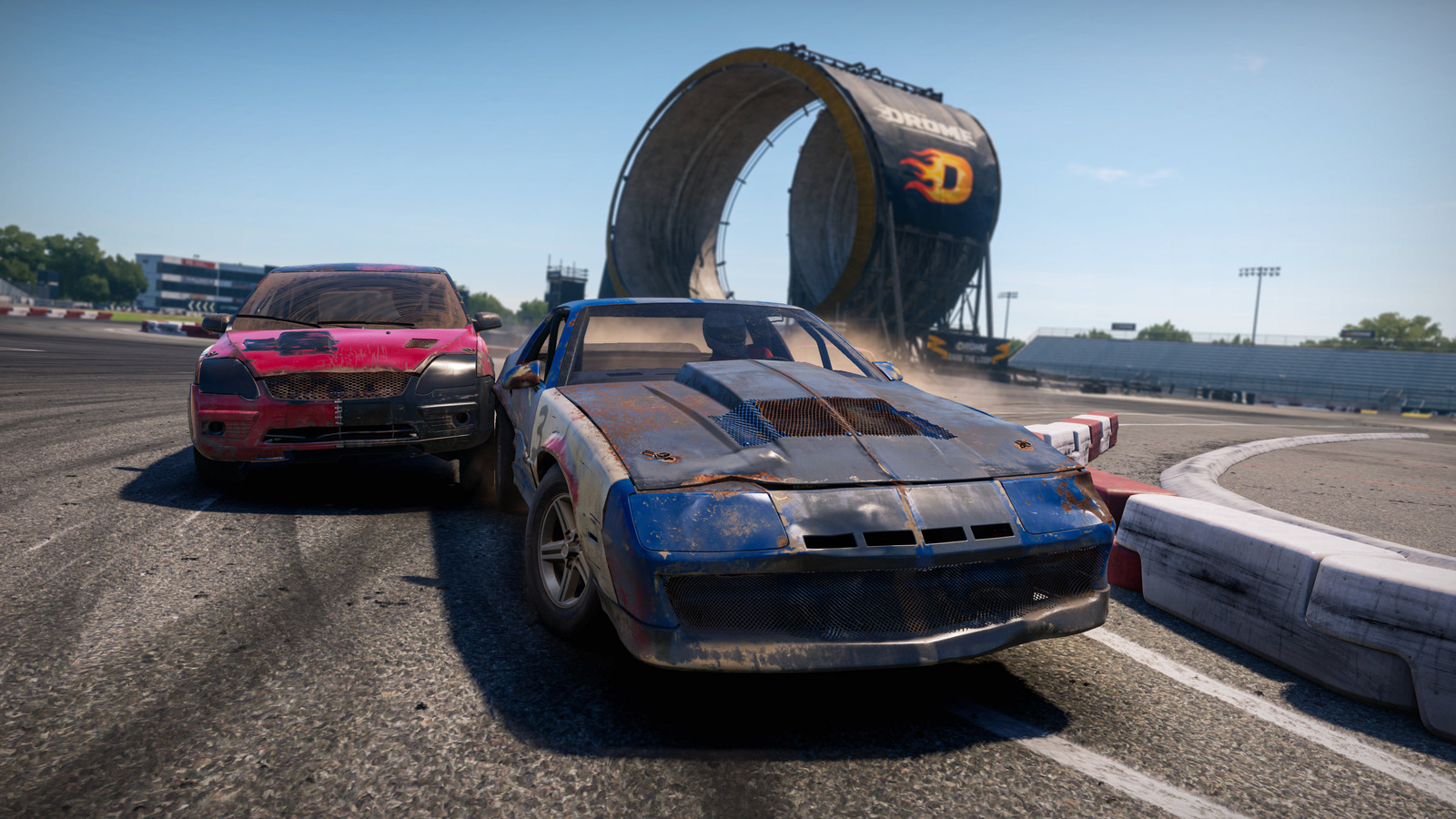 ループを背景に走るWreckfest 2のBladeとFlipper。青い車両の左後方にピンクの車両が接近している。